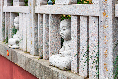 南京绒花摄影照片_南京毗卢寺秋天禅院里的小沙弥雕像特写摄影图配图