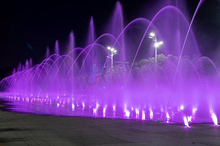 广场上的喷泉表演夜晚喷泉喷泉慢门摄影图配图