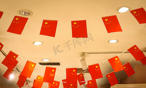中国国旗图摄影照片_国旗室内小红旗店铺仰拍摄影图配图