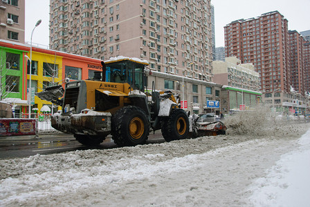 东北雪摄影照片_城市上午推土机马路铲雪摄影图配图