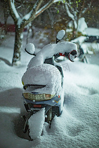 东北雪摄影照片_东北大冬天电动车路边被雪覆盖摄影图配图