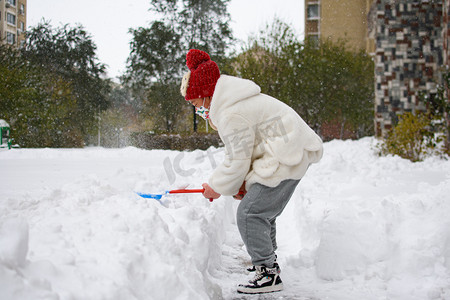 城市上午小女孩雪中玩雪摄影图配图