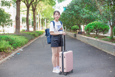 新生入学季摄影照片_新生书包拖箱子大学生摄影图配图