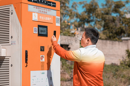 新能源充电白天给新能源汽车充电的人加油站扫码摄影图配图