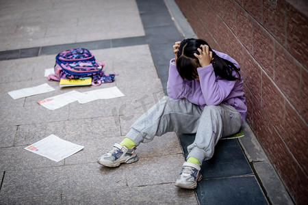 小孩子吃饭摄影照片_人物学生孤独伤心校园暴力摄影图配图