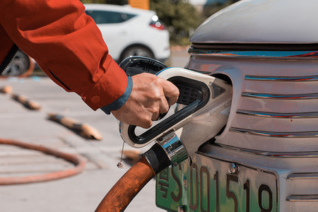 新能源汽车白天给新能源汽车充电加油站充电摄影图配图
