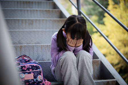 木棉花女孩摄影照片_哭泣伤心小女孩留守儿童人物摄影图配图