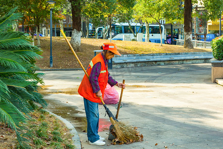 公园扫地的环卫工人一个人公园扫地摄影图配图