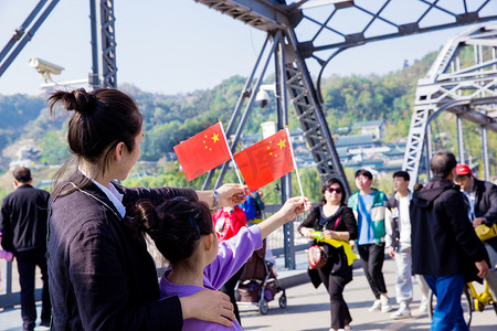 致敬妈妈摄影照片_爱国国旗国庆拿国旗的女孩五星红旗摄影图配图