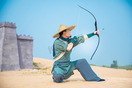 古装男性摄影照片_武侠英雄白天男侠客户外荒漠射箭摄影图配图