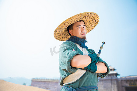 人物古风男摄影照片_武侠英雄白天男侠客户外抱剑摄影图配图