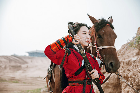 武侠古风摄影照片_武侠白天穿汉服的女侠和战马户外拔剑摄影图配图