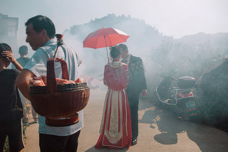 鞭炮炮竹卡通摄影照片_婚庆接亲场景照片上午好多人户外迎亲摄影图配图