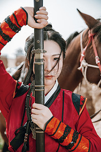 武侠人物摄影照片_武侠白天穿汉服的女侠户外拔剑摄影图配图