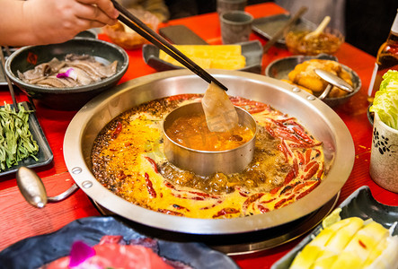 川渝美食摄影照片_社交餐饮夜晚吃火锅的人餐桌涮火锅摄影图配图