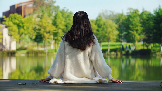 美女坐在湖边欣赏风景人物背影