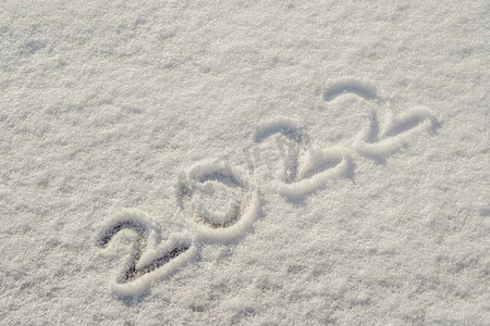 2022联欢会摄影照片_冬天雪地上2022年文字白色积雪摄影图配图