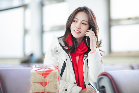 打电话动图摄影照片_春运白天带着红色围巾的的美女候车室打电话摄影图配图