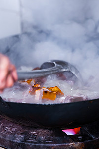 厨房里热气腾腾的卤肉猪肉制作摄影图配图