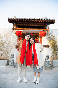 虎年新年喜庆摄影照片_春节幸福甜蜜的情侣手拿糖葫芦开心的笑摄影图配图