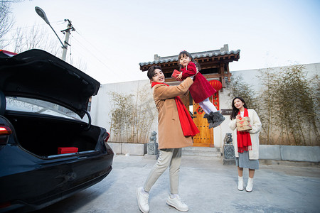 回娘家摄影照片_春节回家爸爸把孩子举高高妈妈在一旁笑摄影图配图