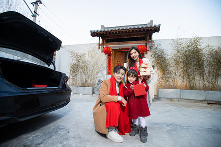 虎年摄影照片_春节爸爸妈妈孩子在门口开心的笑摄影图配图