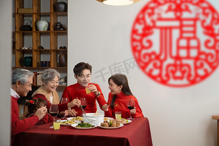 新年除夕年夜饭摄影照片_除夕晚上一家人在开心的吃年夜饭摄影图配图