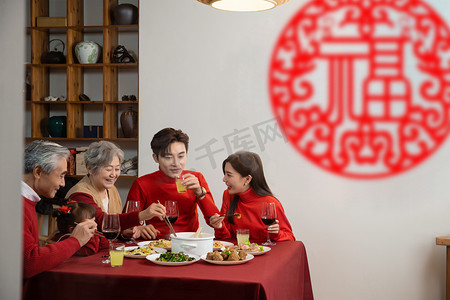 开心小女孩摄影照片_除夕晚上一家人在开心的吃年夜饭摄影图配图