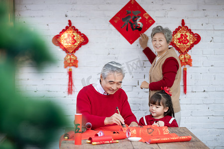 虎年摄影照片_除夕爷爷教小女孩写对联摄影图配图