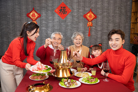 吃年夜饭的人摄影照片_年夜饭一家人开心的吃火锅摄影图配图