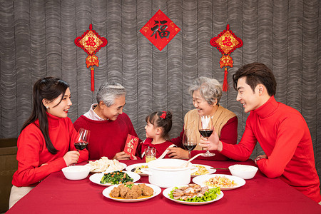 虎年摄影照片_年夜饭餐桌前爷爷给孙女发压岁钱摄影图配图