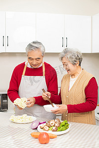 新春纳福摄影照片_过年在厨房里包饺子的两个老人摄影图配图