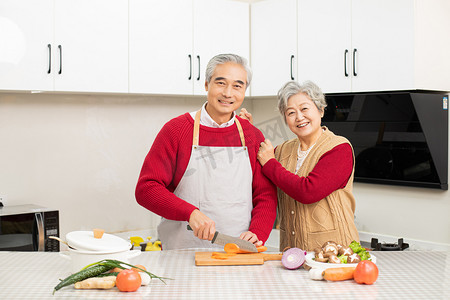 春节习俗大年初三摄影照片_两个老人在厨房做美食摄影图配图