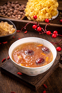 红枣莲子摄影照片_餐饮美食白天红枣莲子羹木纹桌摆放摄影图配图