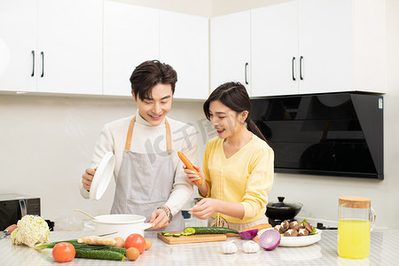 家庭家务白天一对年轻夫妇厨房一起做饭摄影图配图