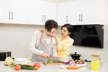 家庭家务白天一对年轻情侣厨房内一起做饭摄影图配图