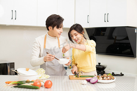 婚恋白天一起做饭的情侣厨房打鸡蛋做家务摄影图配图