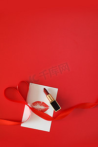 口红竖版摄影照片_情人节妇女节女神节女王节红色背景上的口红摄影图配图