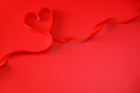 情人节七夕红色背景上的红色丝带摄影图配图