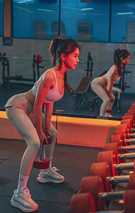 瘦出魔鬼身材摄影照片_美女健身在健身房运动摄影图配图