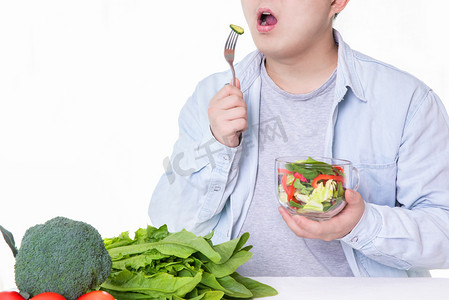 减肥减肥的男人肥胖吃蔬菜健康餐摄影图配图