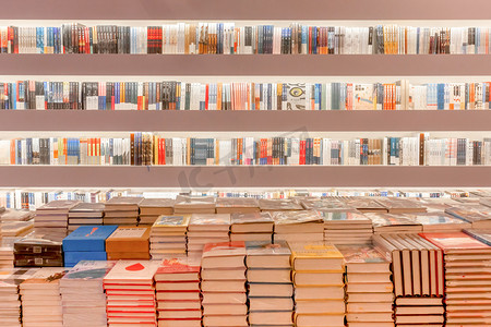 整齐排列的书架和地上堆放的书籍摄影图配图