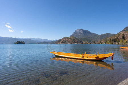 云南泸沽湖的猪槽船和女神山摄影图配图
