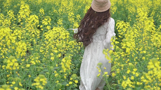 少女花海摄影照片_少女春天油菜花花丛中奔跑