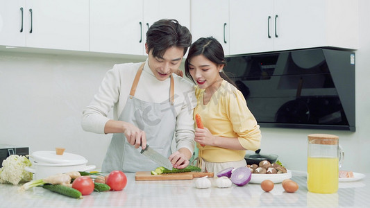 年轻笑容摄影照片_情侣年轻夫妇在厨房一起做饭