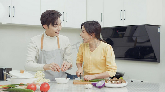 在疫情摄影照片_疫情居家在厨房一起做饭的年轻夫妇情侣