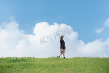 文艺清新美少女侧面在草地上走着摄影图配图