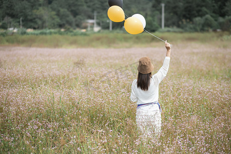 好消息公公众号摄影照片_花海里手拿气球的女子摄影图配图