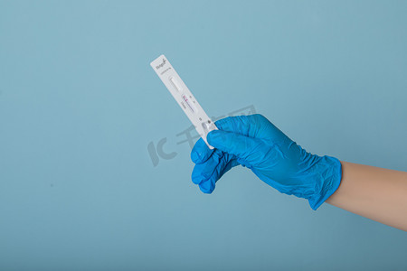 疫情摄影照片_疫情防控白天拿着核酸自测试纸的手室内拿出摄影图配图
