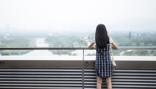 阳台上的女子背影下午女子阳台摄影图配图